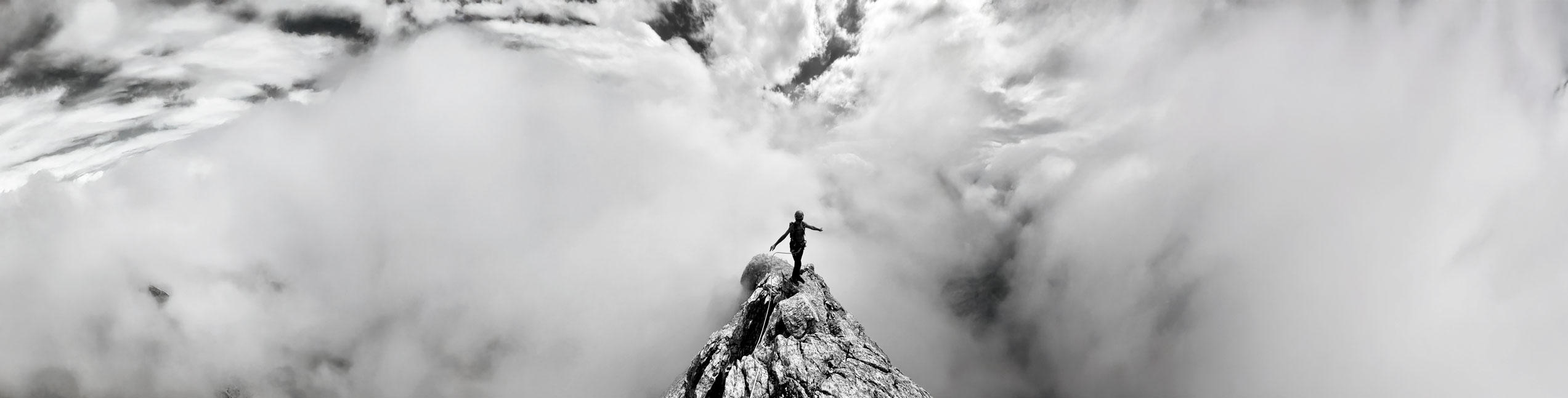 Personnage sur un sommet entouré de nuages